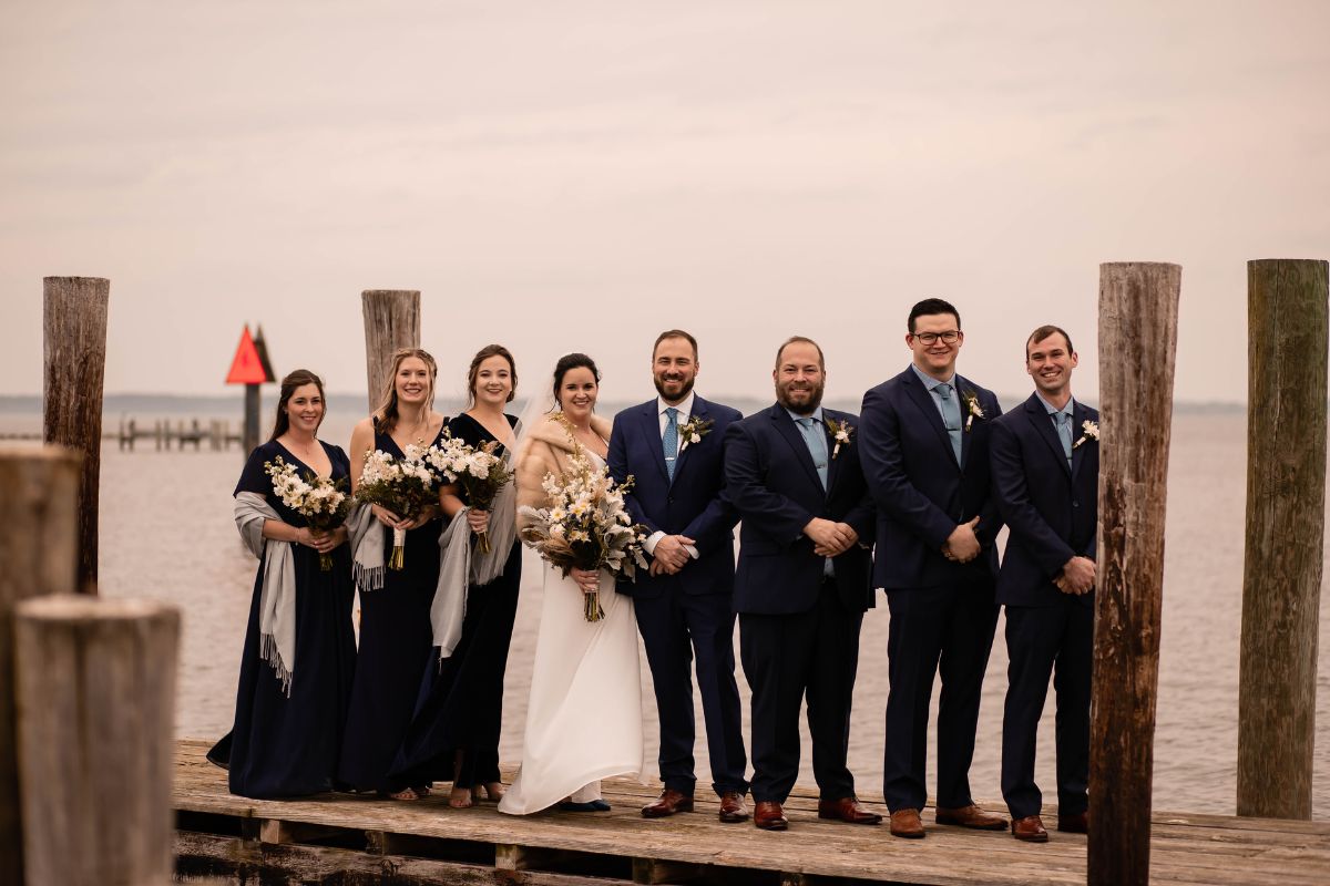 Wedding party line up for photo on dock.