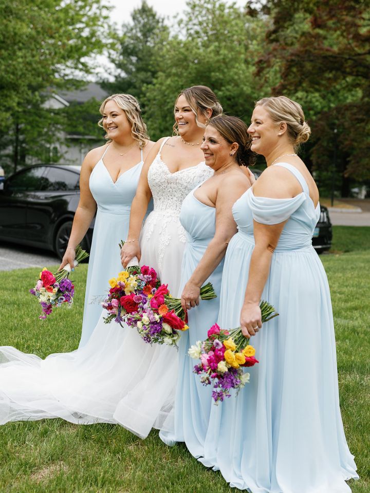Bride and bridesmaids hold bouquets.
