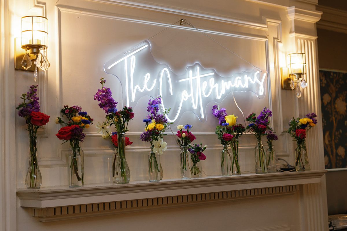 Flower bud vases lined up on fireplace mantel.
