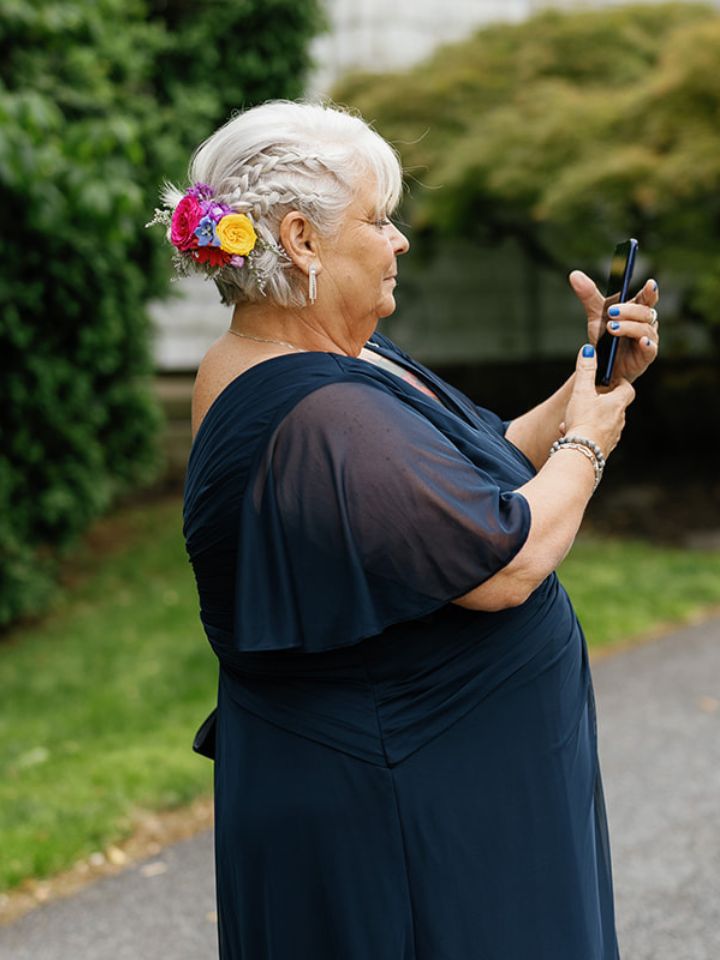 Mother of bride has flower comb in hair.