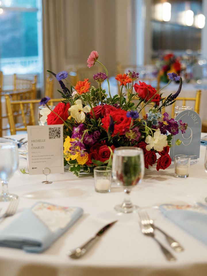 Bright color flower arrangement table centerpiece at a spring wedding.