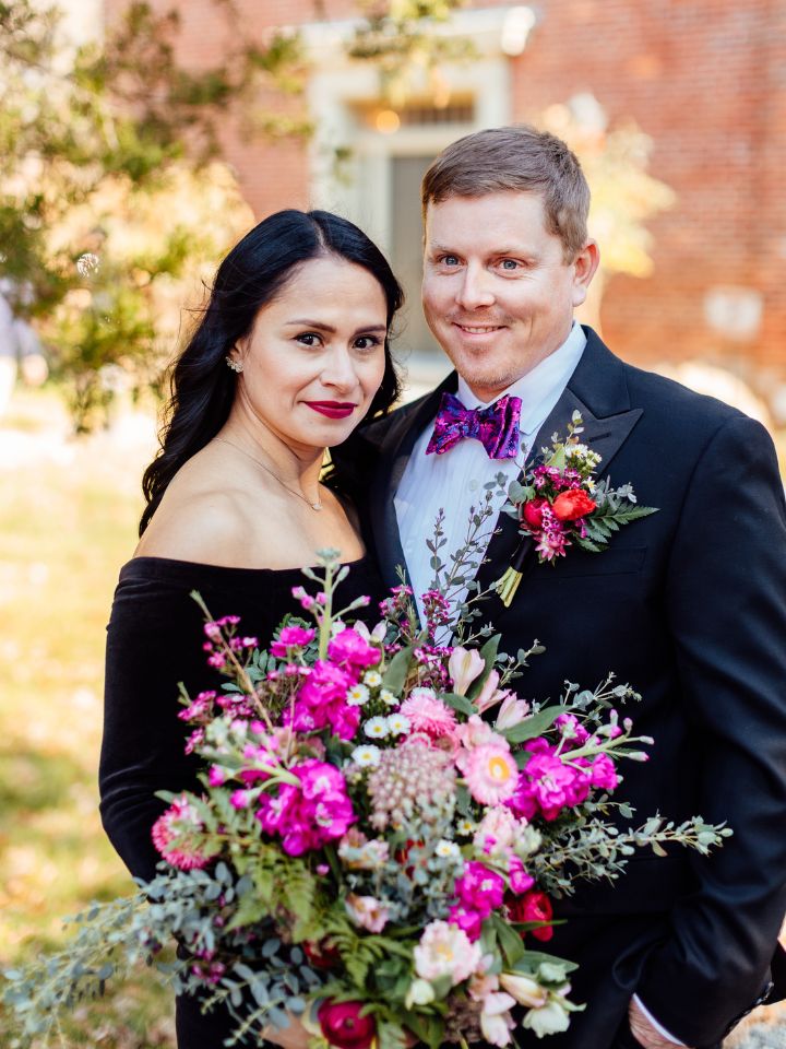 Bride and groom pose outside for their colorful winter elopement.