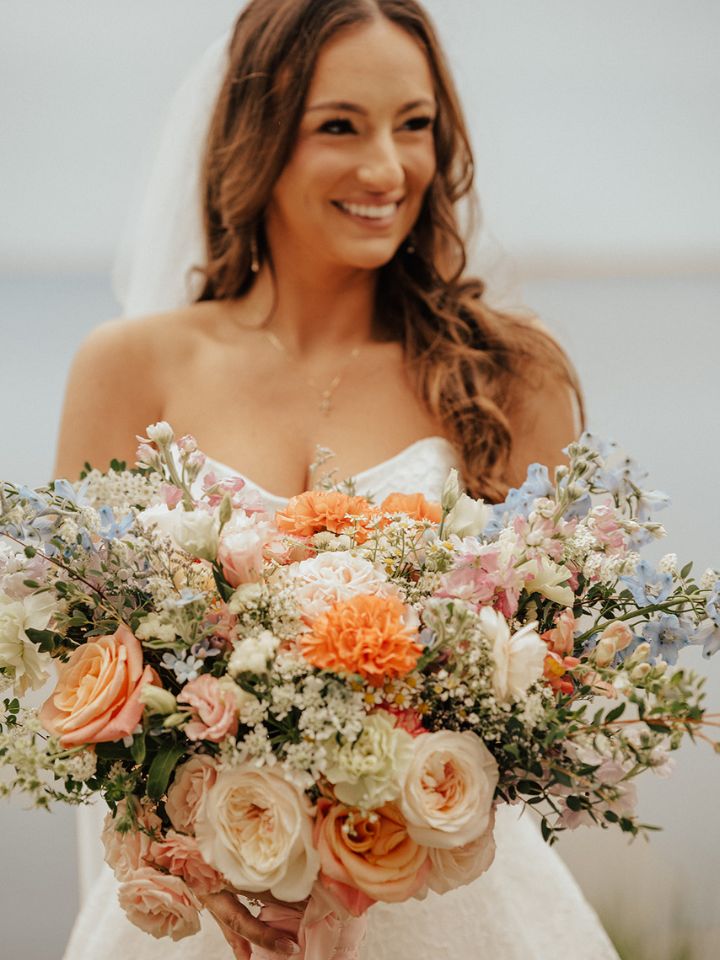 Bride holds her large spring flower bouquet.