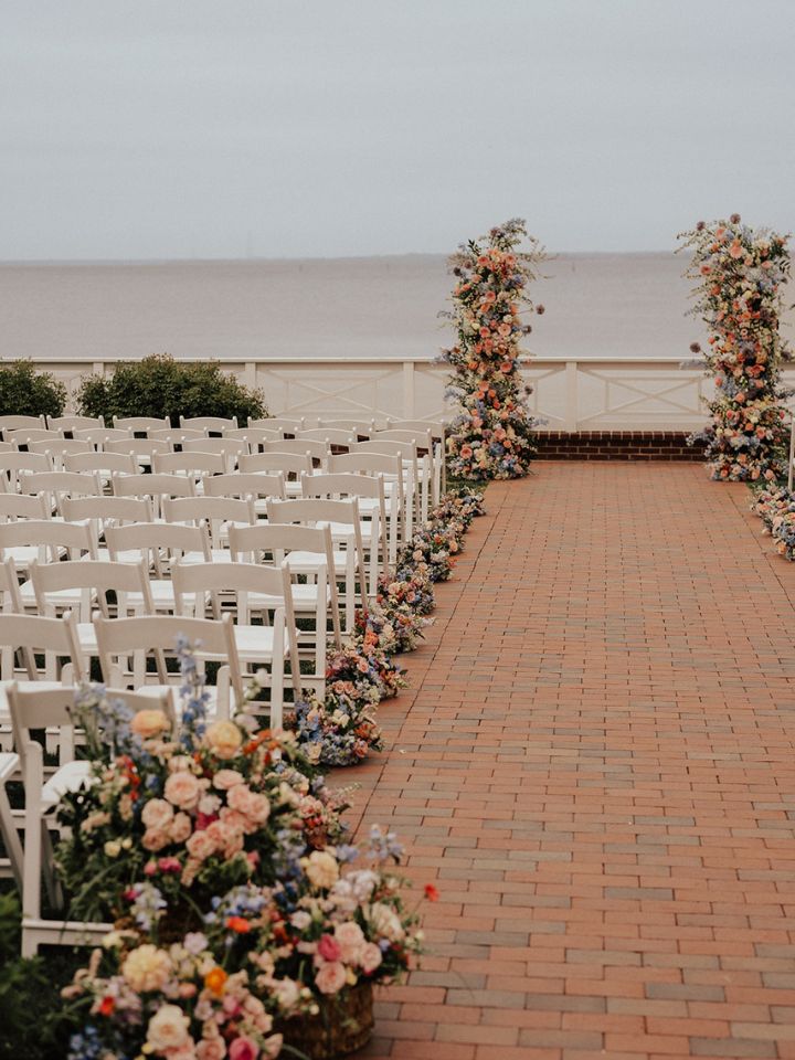 View down ceremony aisle with lots of arrangements.