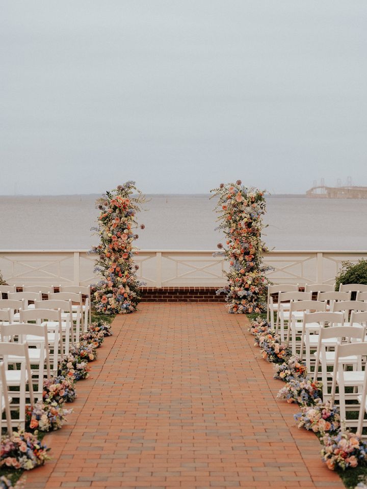 Flower column wedding ceremony flowers at end of aisle.