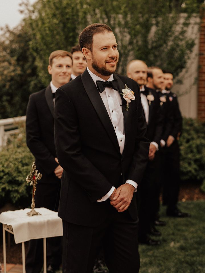 Groom stands at ceremony waiting for bride.
