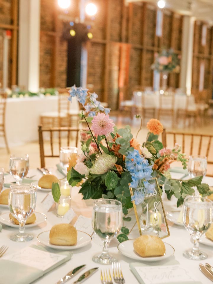 Wedding reception table with flower arrangement centerpiece.