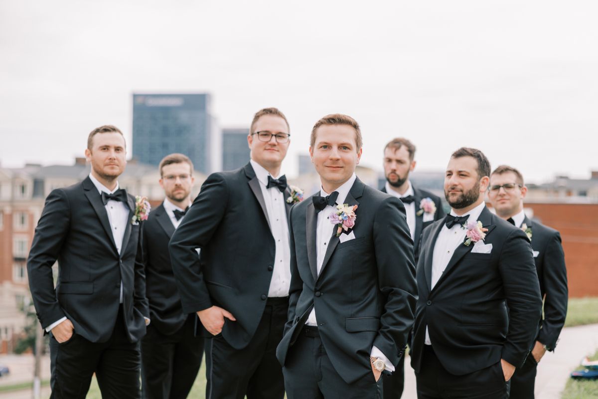 Groom and groomsmen pose in black tuxedos on Fed Hill.