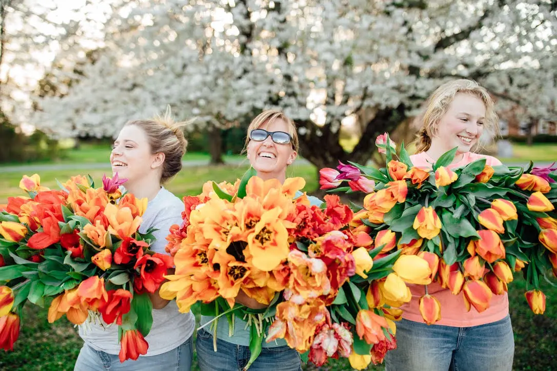 smiling-with-tulips-2021-wildy-native-tean The wildly native flower farm team smiling while carrying bundles of tulips