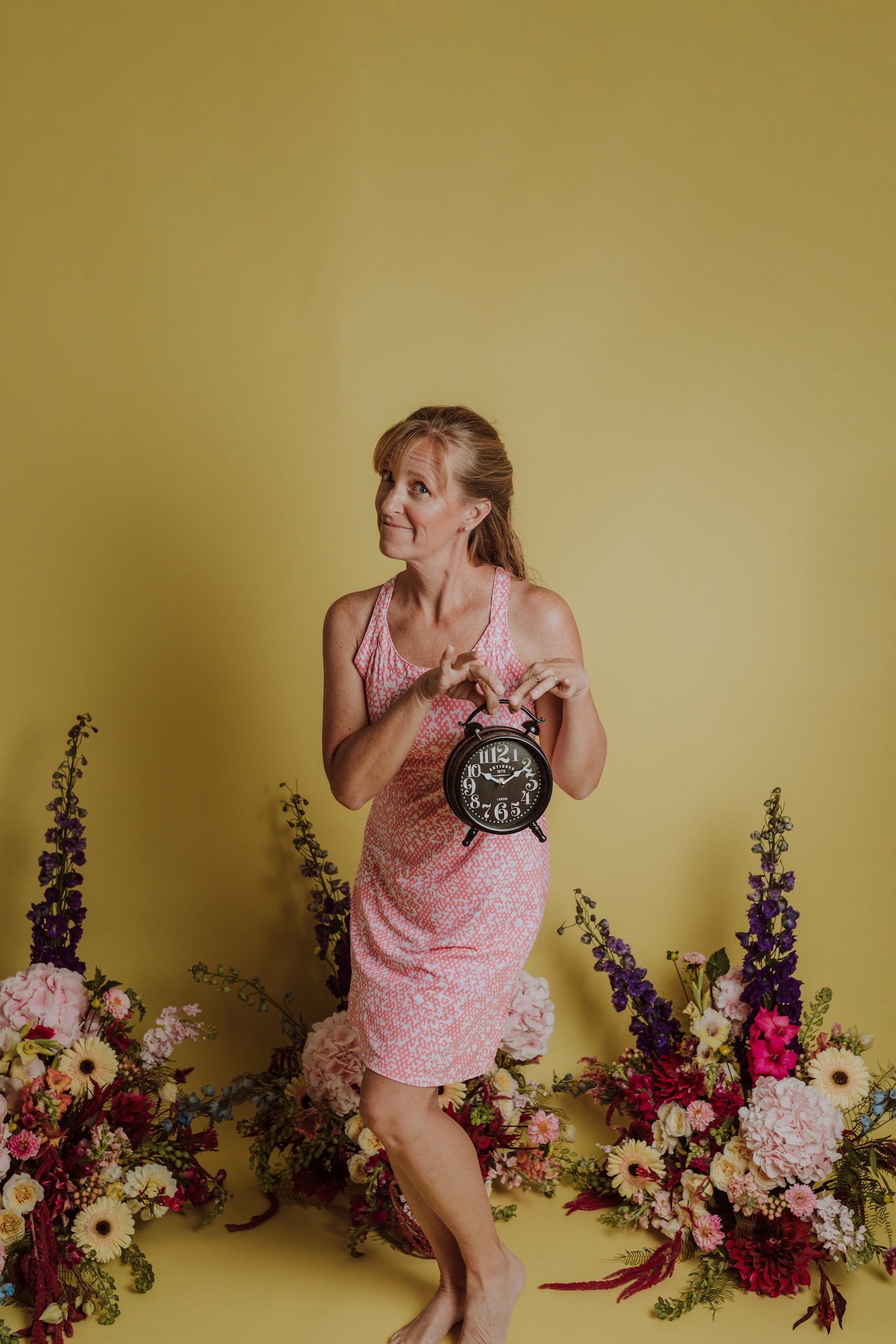 Liza in the studio, holding a clock